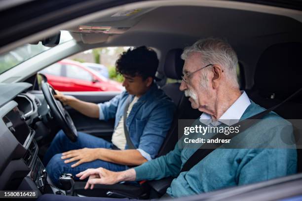 instructor enseña a un joven a conducir en inglaterra - examen de conducir fotografías e imágenes de stock
