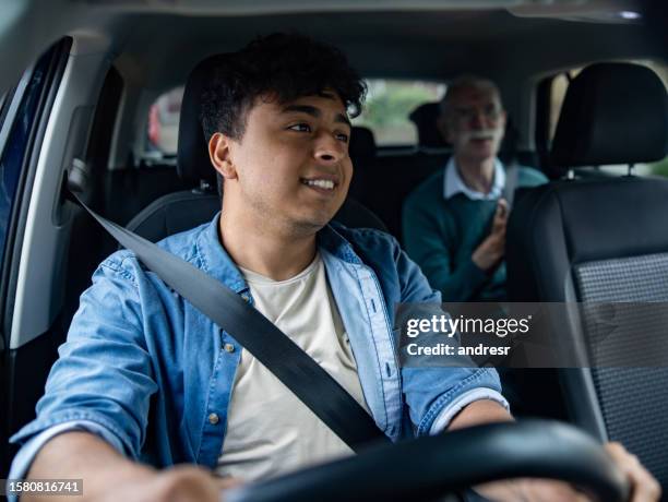 crowdsourced taxi driver driving a senior man to his destination - driving stock pictures, royalty-free photos & images