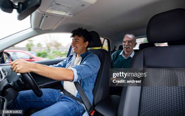 glücklicher crowdsourcing-taxifahrer, der einen älteren mann fährt - fahrgemeinschaft stock-fotos und bilder