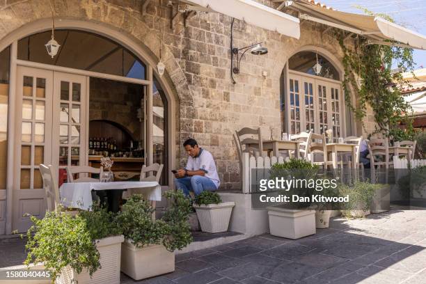 An empty restaurant at lunch time in the old town on July 30, 2023 in Rhodes, Greece. While Rhodes town itself wasn't directly affected by fire...