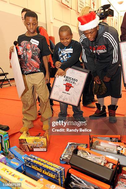 Nate Robinson of the Chicago Bulls assists partygoers with selecting toys during the team's USO / Chicago Housing Authority Holiday Party on December...