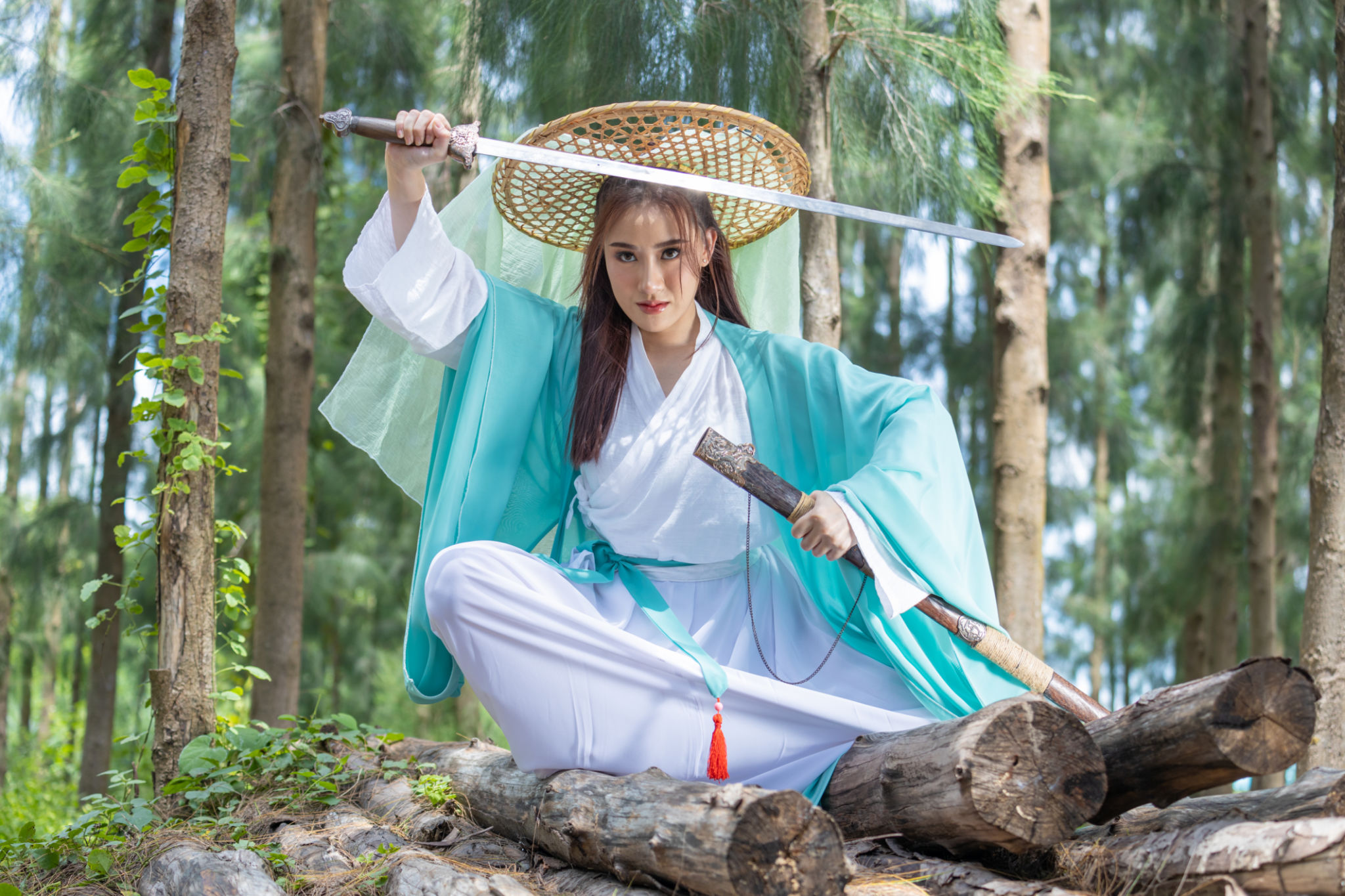 Young beautiful Asian woman dressed in ancient Chinese warrior style with ancient fan. cute girl in green dress Young beautiful Asian woman dressed in ancient Chinese warrior style with ancient fan. cute girl in green dress