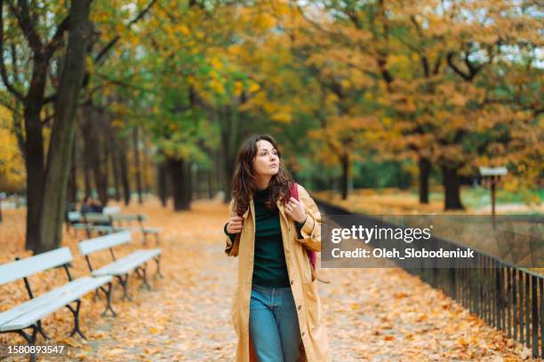 woman walking in the park in autumn and enjoying serenity - poland nature stock pictures, royalty-free photos & images