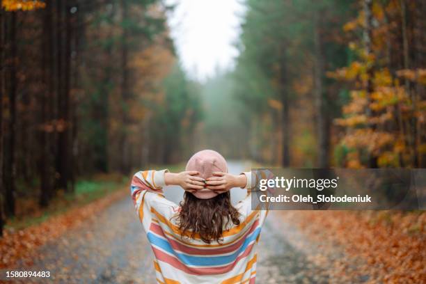 mujer caminando en el bosque de otoño después de la lluvia - noviembre fotografías e imágenes de stock