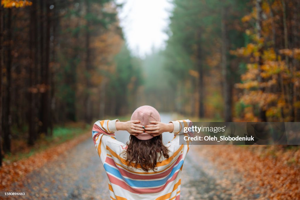 Woman walking in the autumn forest after the rain