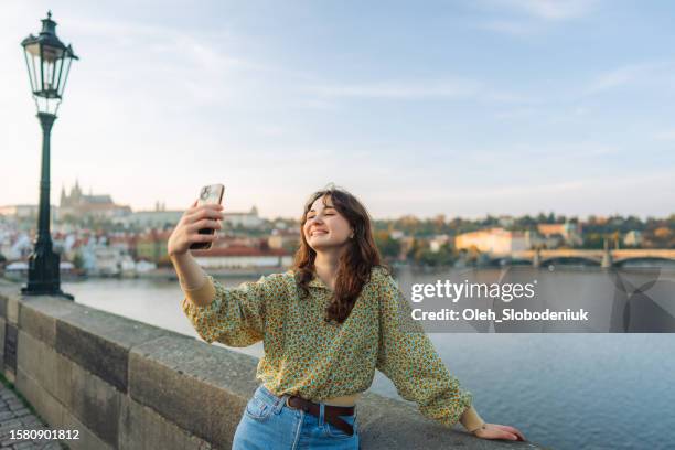 woman making selfie on the karl bridge in prague - prague people stock pictures, royalty-free photos & images