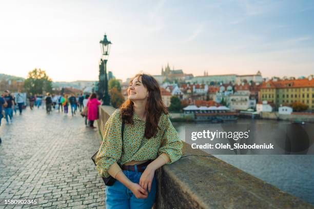 woman walking on karl bridge in prague - prague tourist stock pictures, royalty-free photos & images