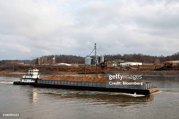 Tow boat pushes a barge of wood chips on the Mississippi River south of St. Louis, Missouri, U.S., on Friday, Dec. 7, 2012. Barges carrying grain,...