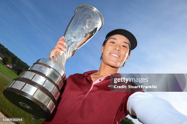 Celine Boutier of France imitates a selfie as she poses with the Amundi Evian Championship trophy following victory in the Final Round of the Amundi...