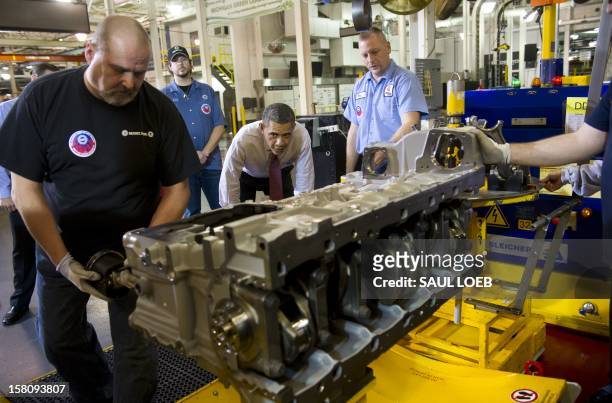 President Barack Obama talks with workers as they perform work on an engine during a tour of the Daimler Detroit Diesel Plant in Redford, Michigan,...