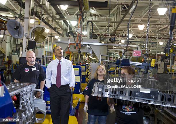 President Barack Obama talks with workers as they perform work on an engine during a tour of the Daimler Detroit Diesel Plant in Redford, Michigan,...
