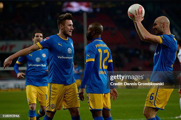 Dominik Kumbela of Braunschweig celebrates with teammates after scoring his team's first goal during the Bundesliga match between 1. FC Koeln and...