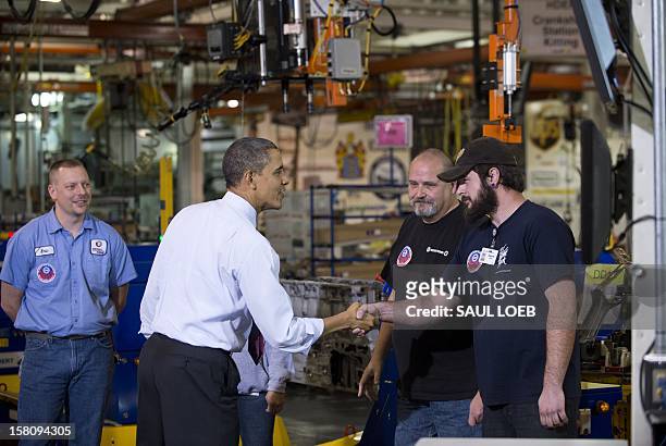 President Barack Obama shakes hands with workers as they perform work on an engine during a tour of the Daimler Detroit Diesel Plant in Redford,...