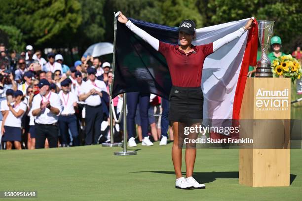 Celine Boutier of France celebrates alongside the Amundi Evian Championship trophy following victory in the Amundi Evian Championship at Evian Resort...