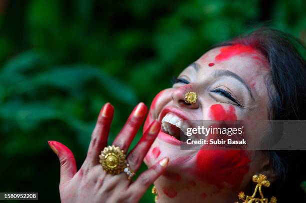 celebrating devotion and tradition: a hindu woman adorns 'sindur' in joyful farewell to durga puja festivities in kolkata, india. - saraswati puja stock pictures, royalty-free photos & images