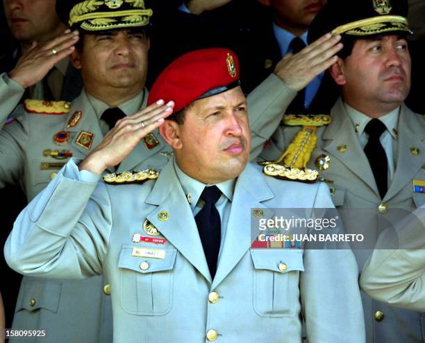 Venezuelan President Hugo Chavez listens to the national anthem next to military's higher commanders during a commemorative military parade for the...