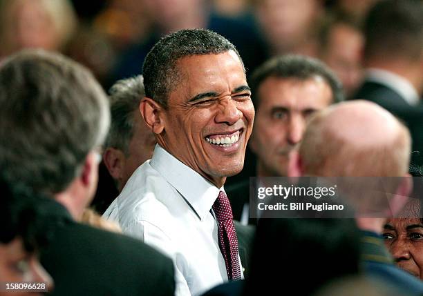 President Barack Obama greets the crowd after he spoke about the economy at the Daimler Detroit Diesel engine plant December 10, 2012 in Redford,...