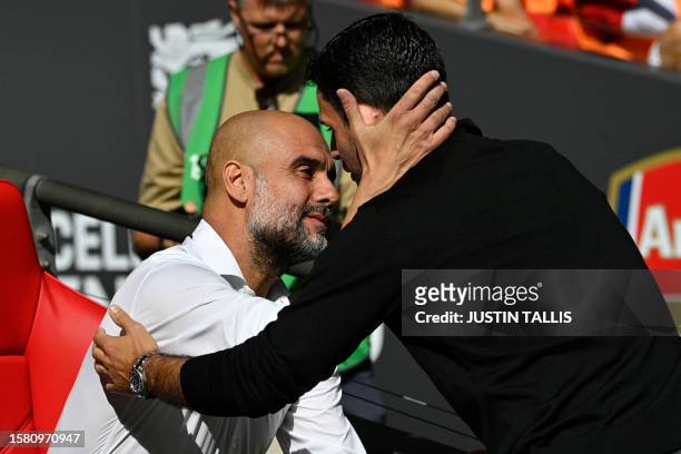 Manchester City's Spanish manager Pep Guardiola and Arsenal's Spanish manager Mikel Arteta embrace ahead of kick-off in the English FA Community...