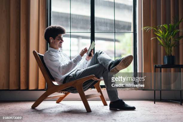 handsome smiling businessman having a relaxed video chat at home - dress code stock pictures, royalty-free photos & images