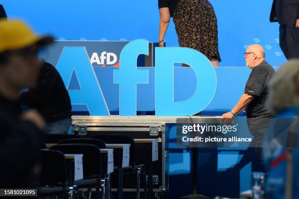 August 2023, Saxony-Anhalt, Magdeburg: Helpers push the AfD logo out of the exhibition hall after the AfD European election meeting. The delegates...