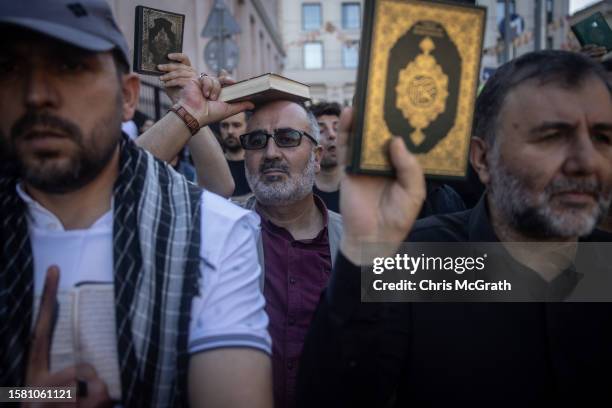 People hold copies of the Quran during a protest outside the Swedish Consulate on July 30, 2023 in Istanbul, Turkey. Protests have erupted across the...