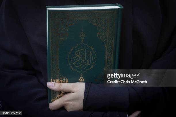 Woman holds a copy of the Quran during a protest outside the Swedish Consulate on July 30, 2023 in Istanbul, Turkey. Protests have erupted across the...
