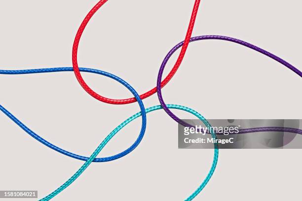 four curve ropes crossed and converged together - things that go together stock pictures, royalty-free photos & images