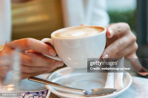 mujer sosteniendo una taza de café - saucer fotografías e imágenes de stock