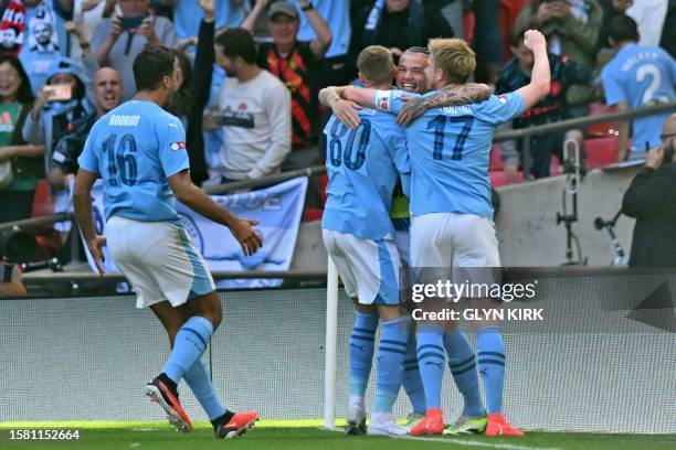 Manchester City's English midfielder Cole Palmer celebrates with teammates after scoring the opening goal of the English FA Community Shield football...