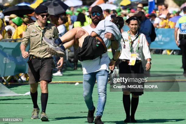 Woman is evacuated due to heat exhaustion during a meeting with volunteers of the World Young Day in Alges, 10 km away from Lisbon, on August 6,...