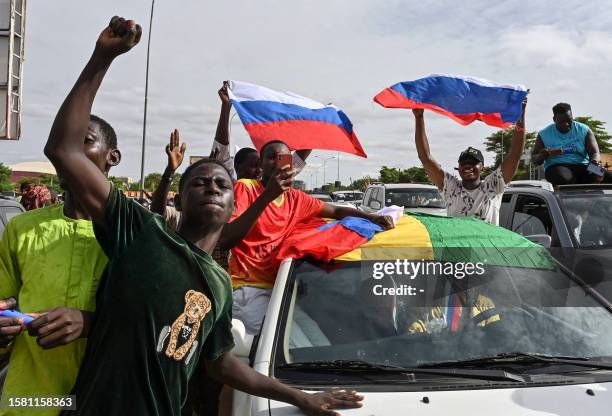 Supporters of Niger's National Council for the Safeguard of the Homeland wave Russian flags as they demonstrate in Niamey on August 6, 2023....