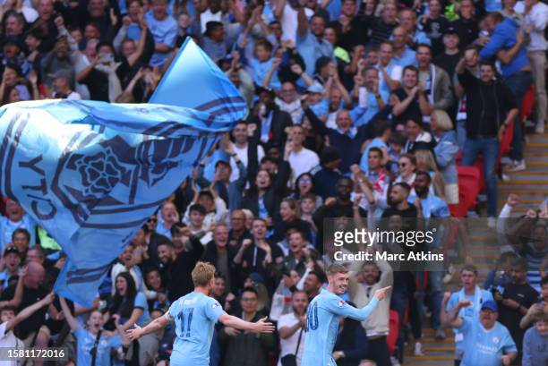 Manchester City's Cole Palmer celebrates scoring their first goal with Manchester City's Kevin De Bruyne during The FA Community Shield match between...