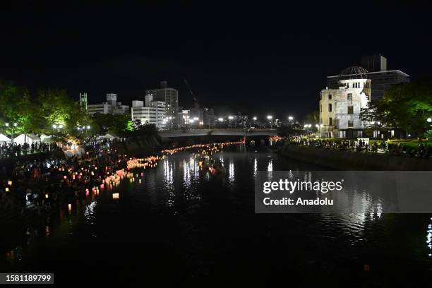 People attend the Peace Message Lantern Floating Ceremony at the Hiroshima Peace Memorial Park to pay tribute to the atomic bomb victims in...