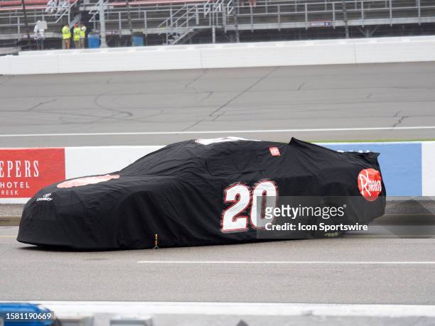 Tarp covers Christopher Bell on pit road before the NASCAR Cup Series FireKeepers Casino 400 on August 06 at Michigan International Speedway in...