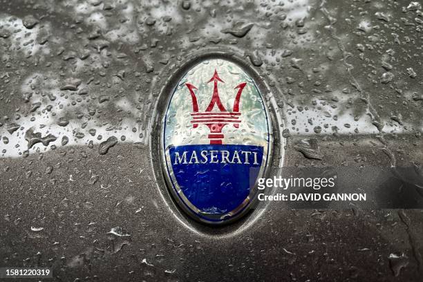 The logo of Italian luxury vehicle manufacturer Maserati is seen on the raindrop-covered bonnet of a Maserati car in Berlin on August 6, 2023.