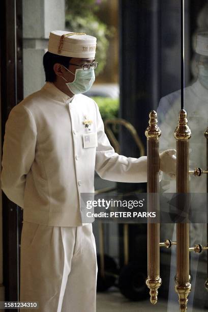 Doorman at the Pennisula Hotel in Hong Kong wears a mask to protect against the killer outbreak of pneumonia in the territory, 09 April 2003. The...