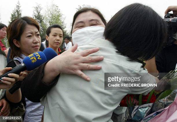 Recovered Severe Acute Respiratory Syndrome patient hugs a military medic upon release from the Xiaotangshan SARS Hospital on the rural outskirts of...