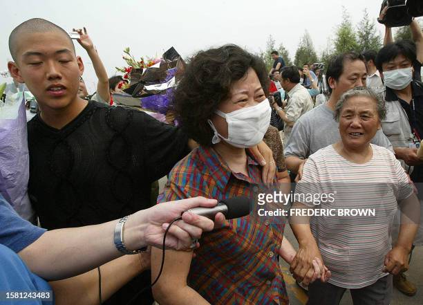 Recovered Severe Acute Respiratory Syndrome patient Hong Yu walks with family members after being released from the Xiaotangshan SARS Hospital on the...