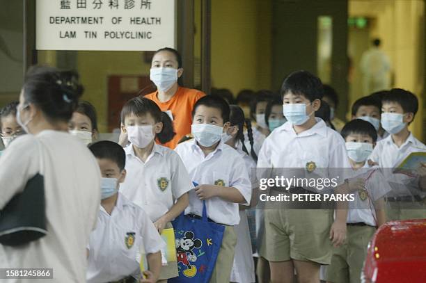 Primary school children line-up to get on a bus after visiting a clinic in Lam Tin, Hong Kong,11 June 2003 where a two-year-old primary schoolboy has...