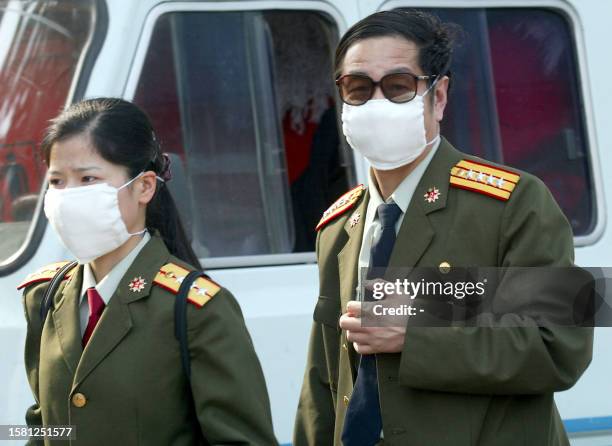 Senior Chinese People's Liberation Army medical officer arrives with an aide to inspect the hospital erected in barely a week to house a rapidly...