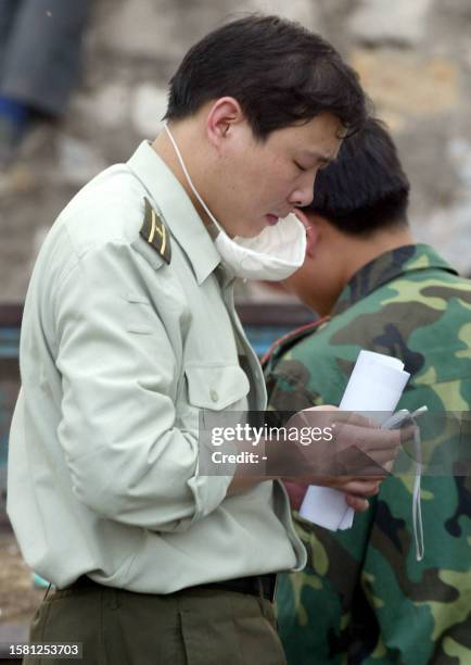 Chinese People's Liberation Army medical officer makes a call from his mobile phone from the hospital erected in barely a week to house a rapidly...