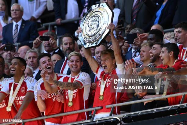 Arsenal's Norwegian midfielder Martin Odegaard lifts the trophy after Arsenal win the shoot-out after the English FA Community Shield football match...