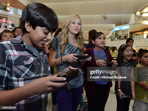 Karan Brar and Olivia Holt stars of Disney Channel’s hit series "Jessie" battle in the Wii U Showdown at Westfield Century City Mall in Los Angeles...