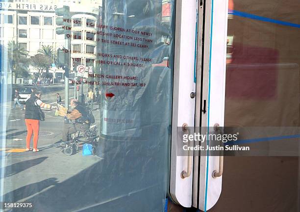 Homeless man is seen reflected in a window as he receives a donation on December 10, 2012 in San Francisco, California. Despite efforts from the...