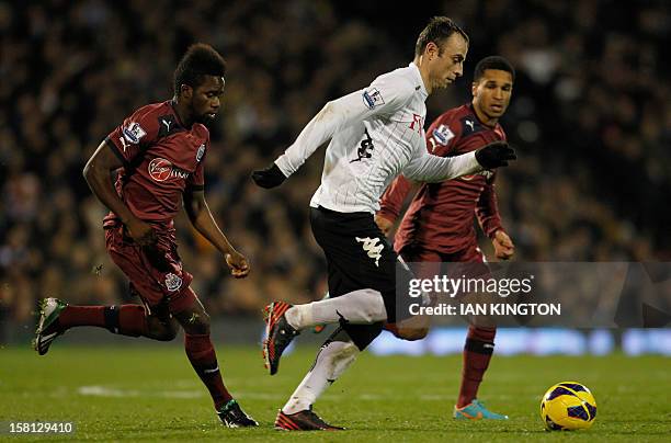Fulham's Bulgarian striker Dimitar Berbatov runs with the ball chased by Newcastle United's Burundian midfielder Gael Bigirimana during the English...