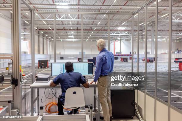 manager with a worker working on computer in agv control room at warehouse - agv stock pictures, royalty-free photos & images