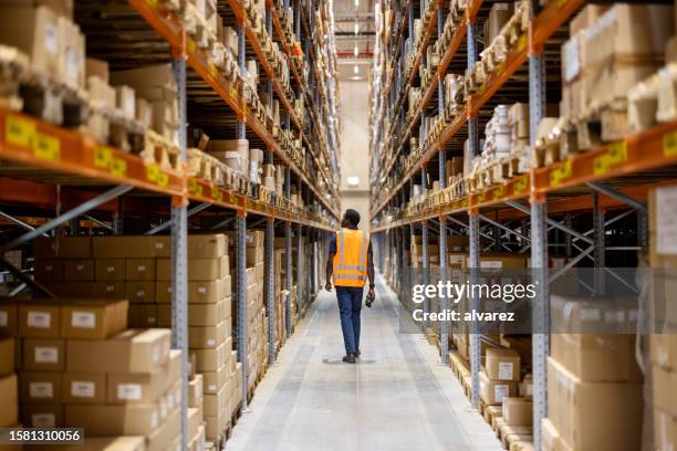 distribution warehouse employee walking in storage facility - loja de ferragens imagens e fotografias de stock