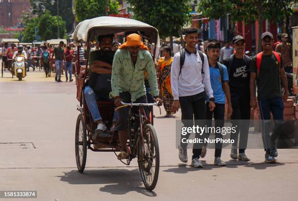 Rickshaw puller transports people on a cycle rickshaw in Chandni Chowk, Old Delhi on August 6, 2023.