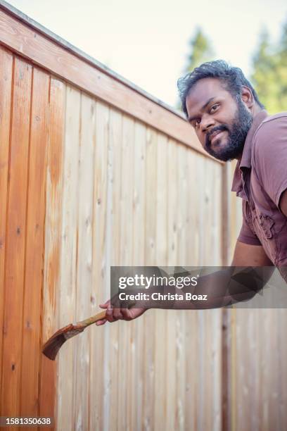 east indian staining a fence - christa stock pictures, royalty-free photos & images