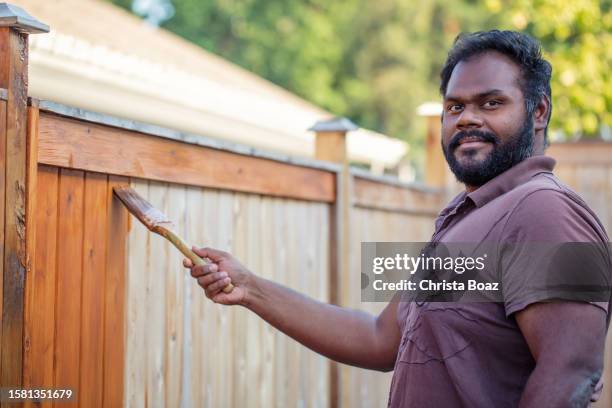 east indian staining a fence - christa stock pictures, royalty-free photos & images